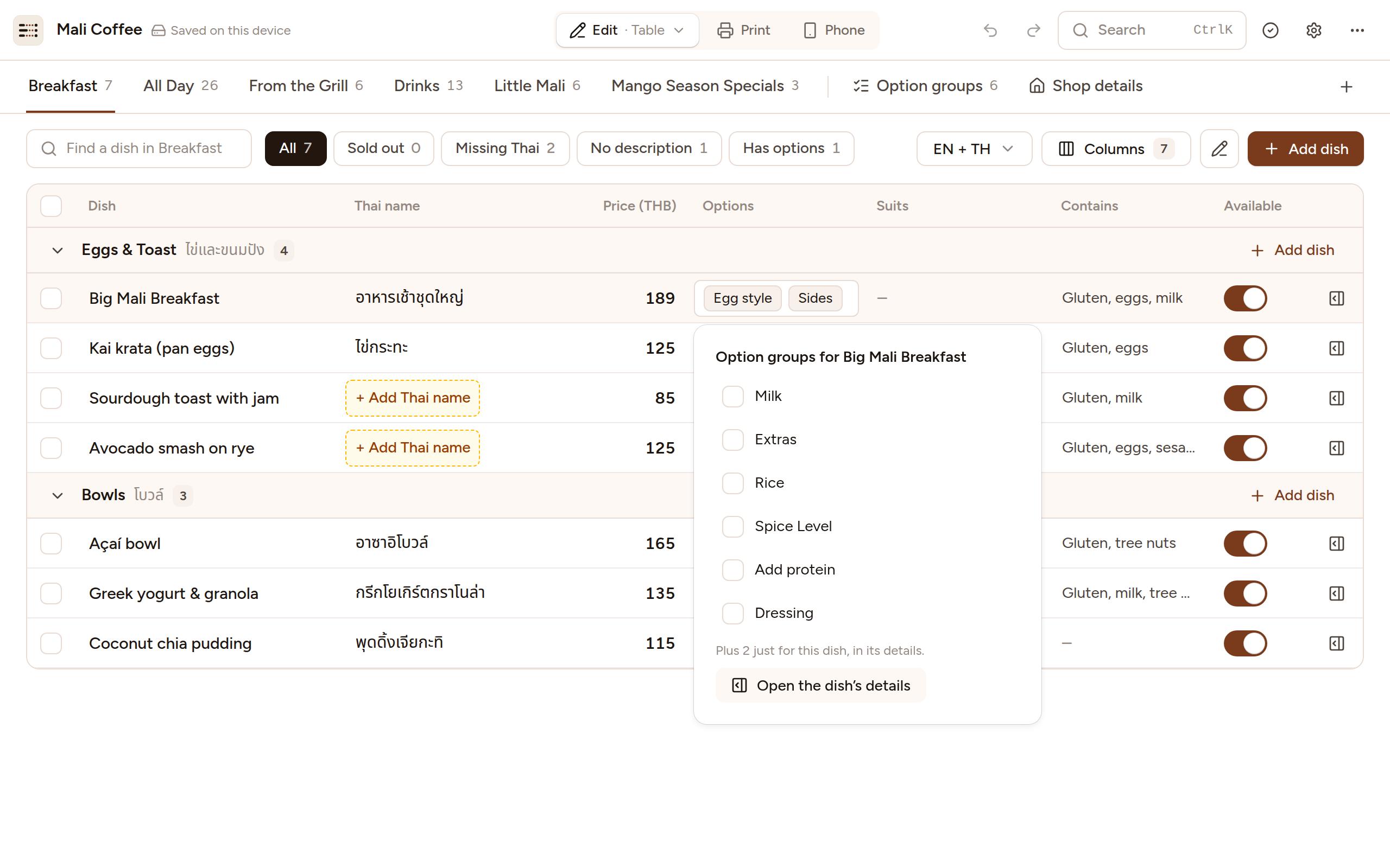 Screenshot of the Menu Studio editor’s Table layout with the sample menu open: a row per dish with its Thai name, price, options, what it contains and whether it’s available, and the option groups for Big Mali Breakfast open in a popover.